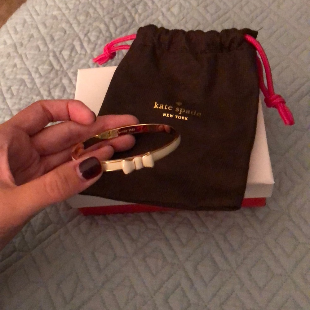 Kate Spade “Take a Bow Bangle” in cream + gold